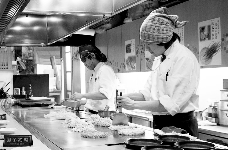 Cuisiniers préparant des okonomiyaki dans un restaurant japonais
